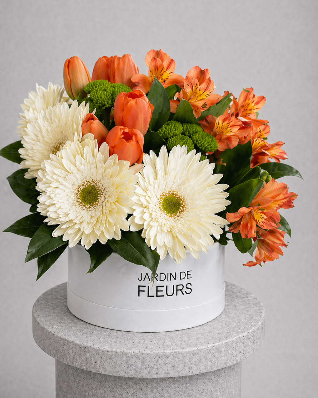 Floral arrangement in a white box labeled 'Jardin de Fleurs' on a gray pedestal with a gray background