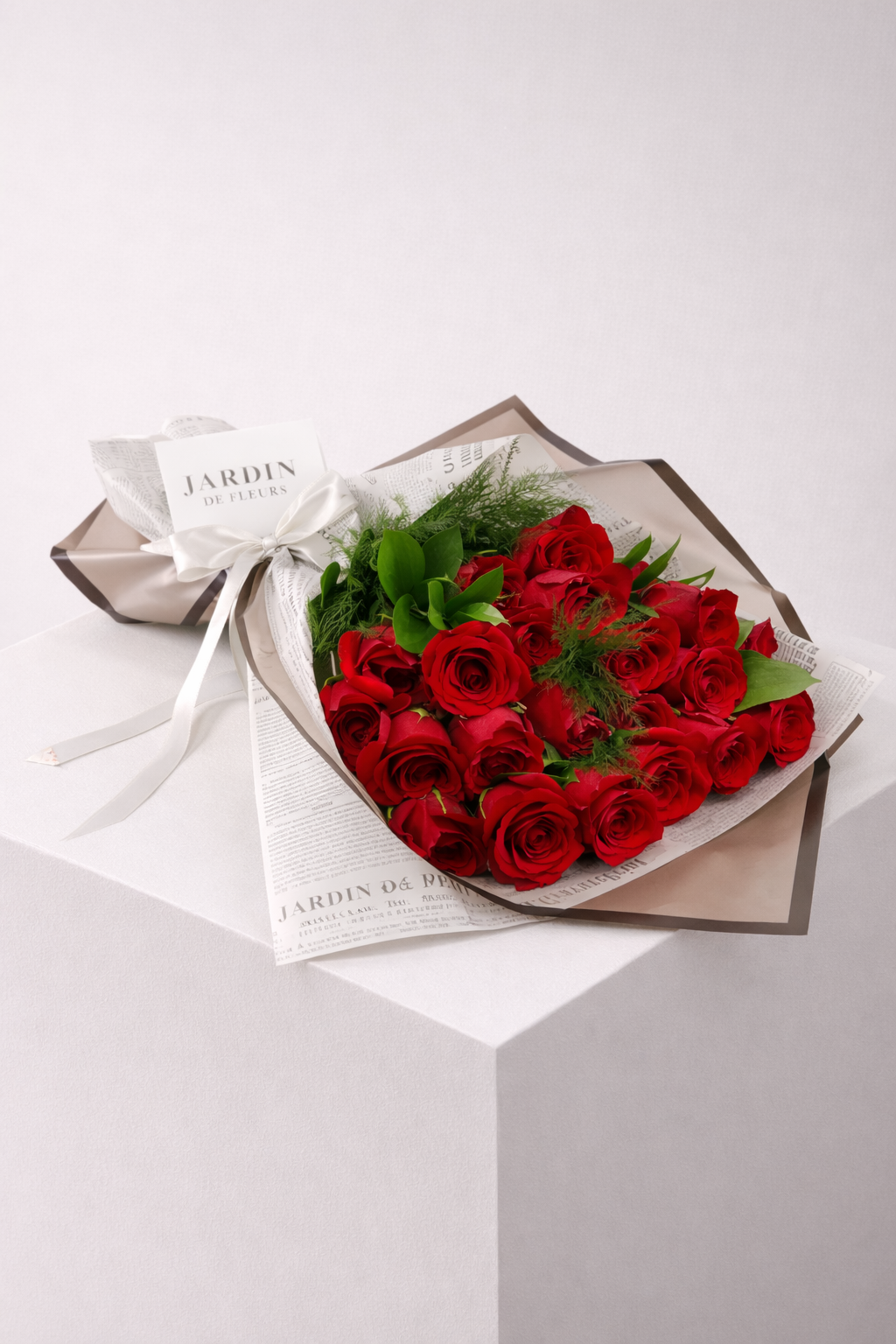 Bouquet of red roses with a white ribbon on a light gray background