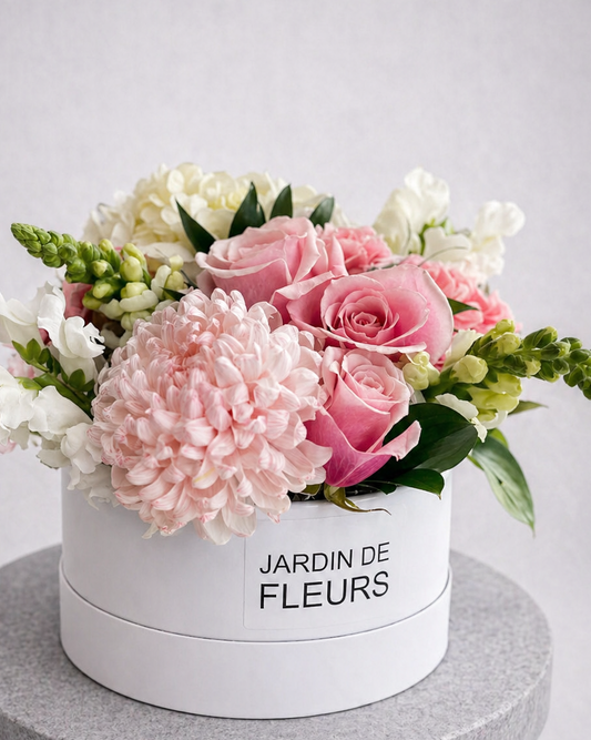 Floral arrangement in a white box labeled 'Jardin de Fleurs' on a gray pedestal against a light gray background