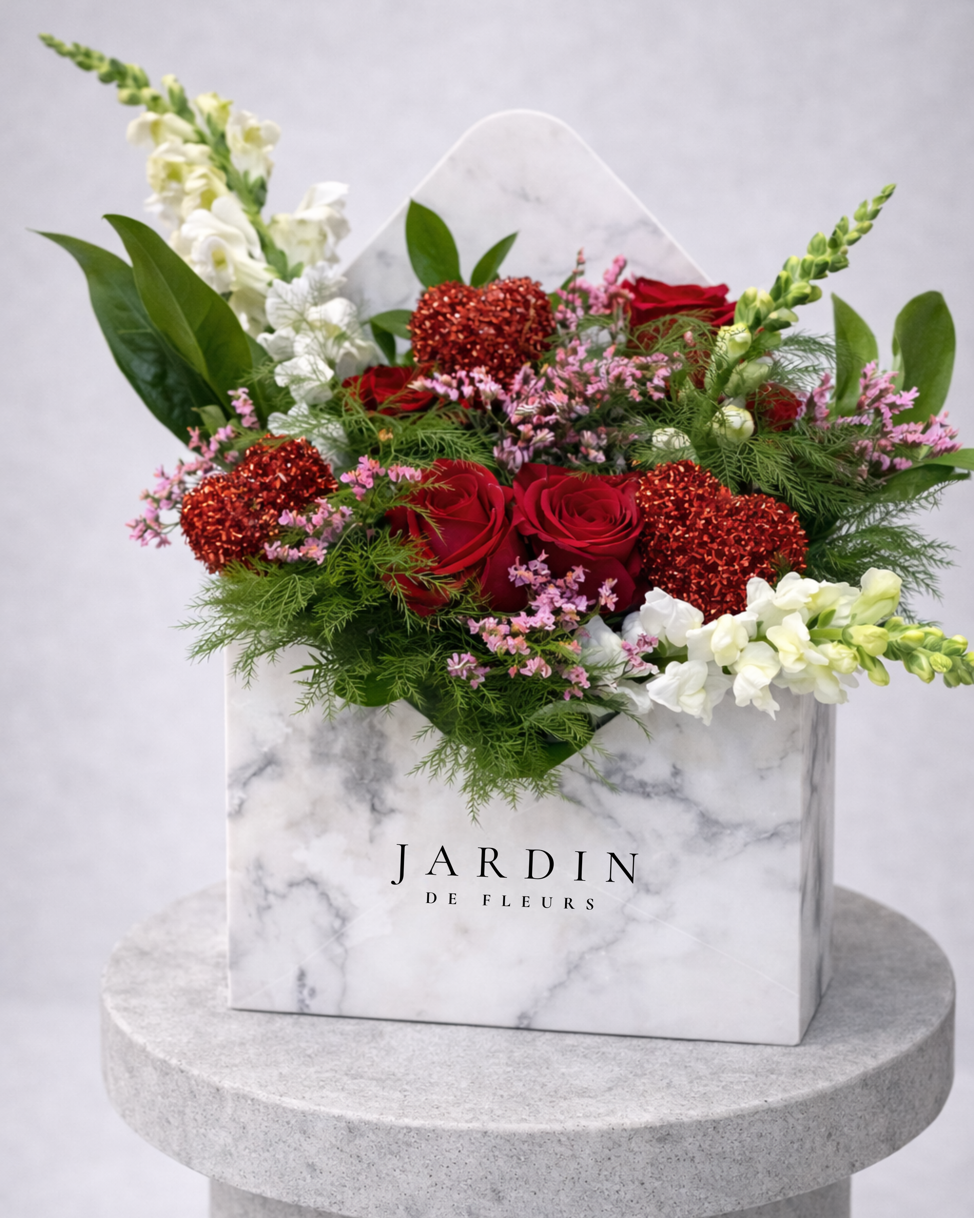 Floral arrangement in a marble box with 'Jardin de Fleurs' branding on a gray background